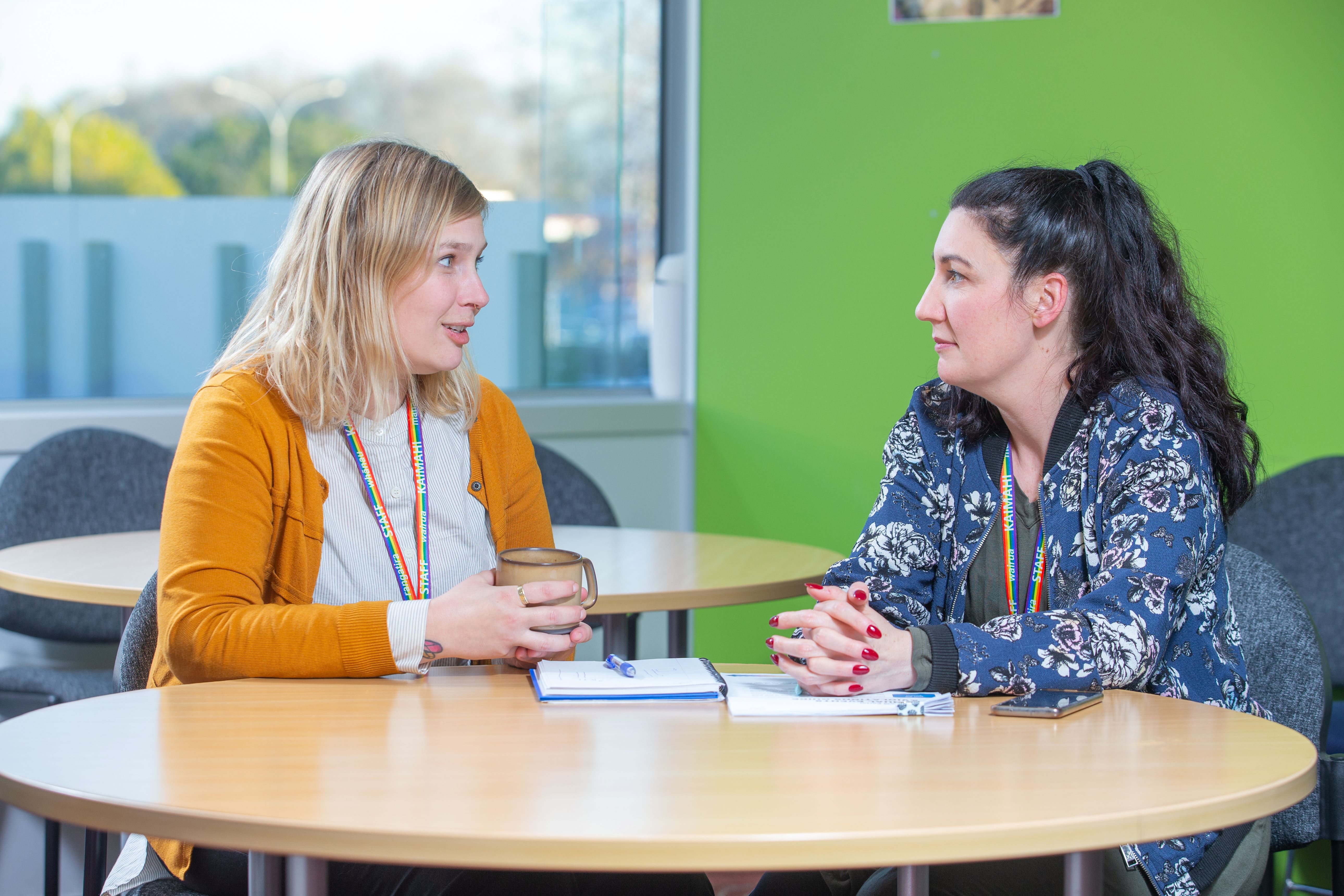 Community Corrections staff talk together at a table in staff room